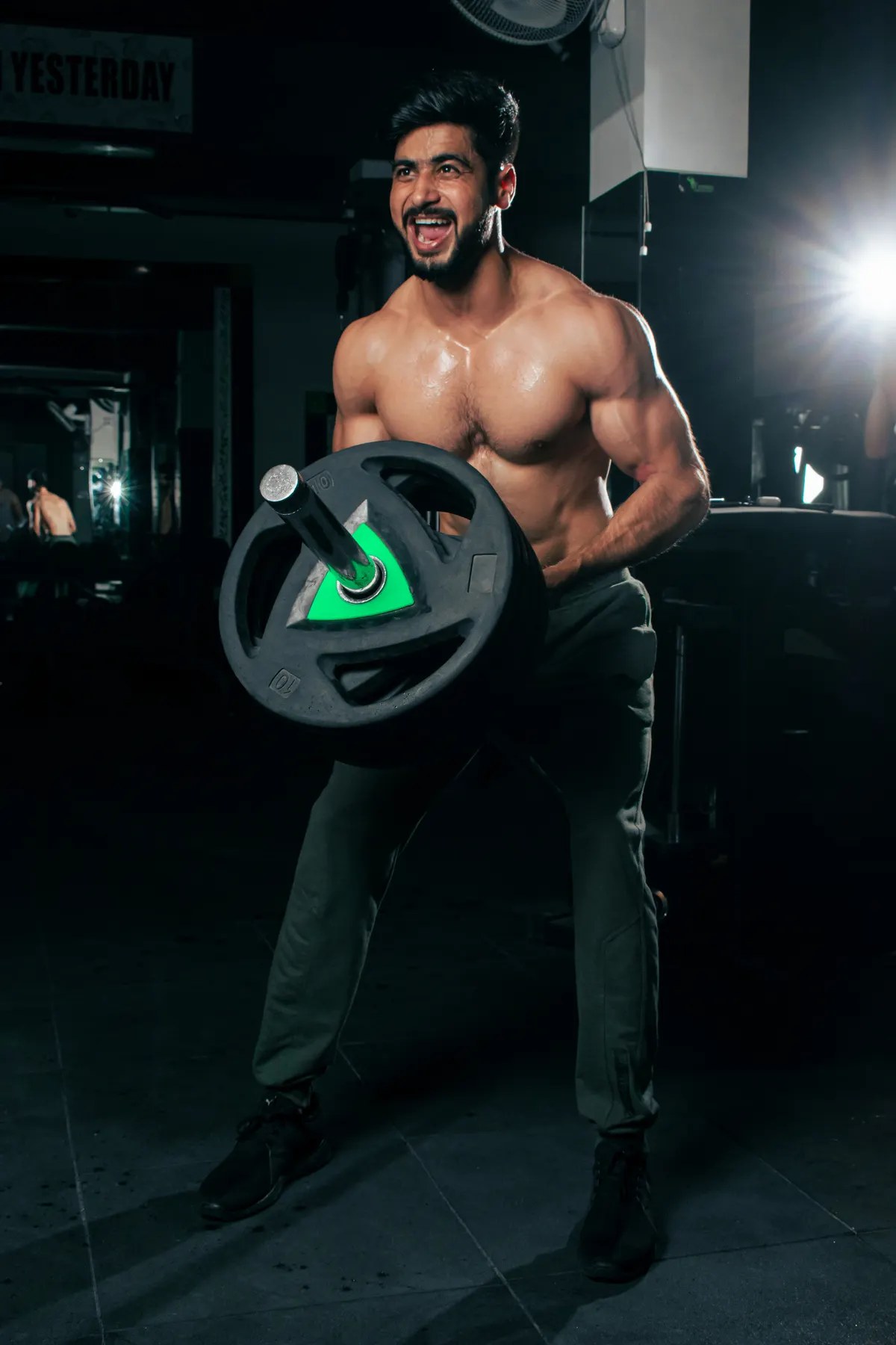 Athlete resting between gym sets in a dark training space
